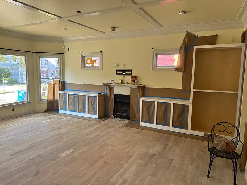 Built-in cabinets and fireplace covered with protective paper in an empty room. reconstruction services