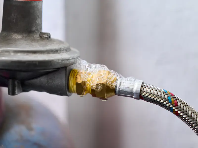 Gas valve connection leaking with soap bubbles on a braided hose fitting. leak detection services